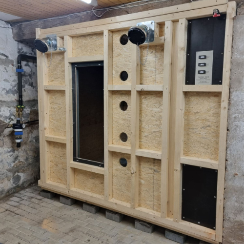 Großes individuell an den Raum angepasstes Pellet Lager aus OSB-Platten mit zwei großen Einfüllstutzen im Heizraum eingebaut.